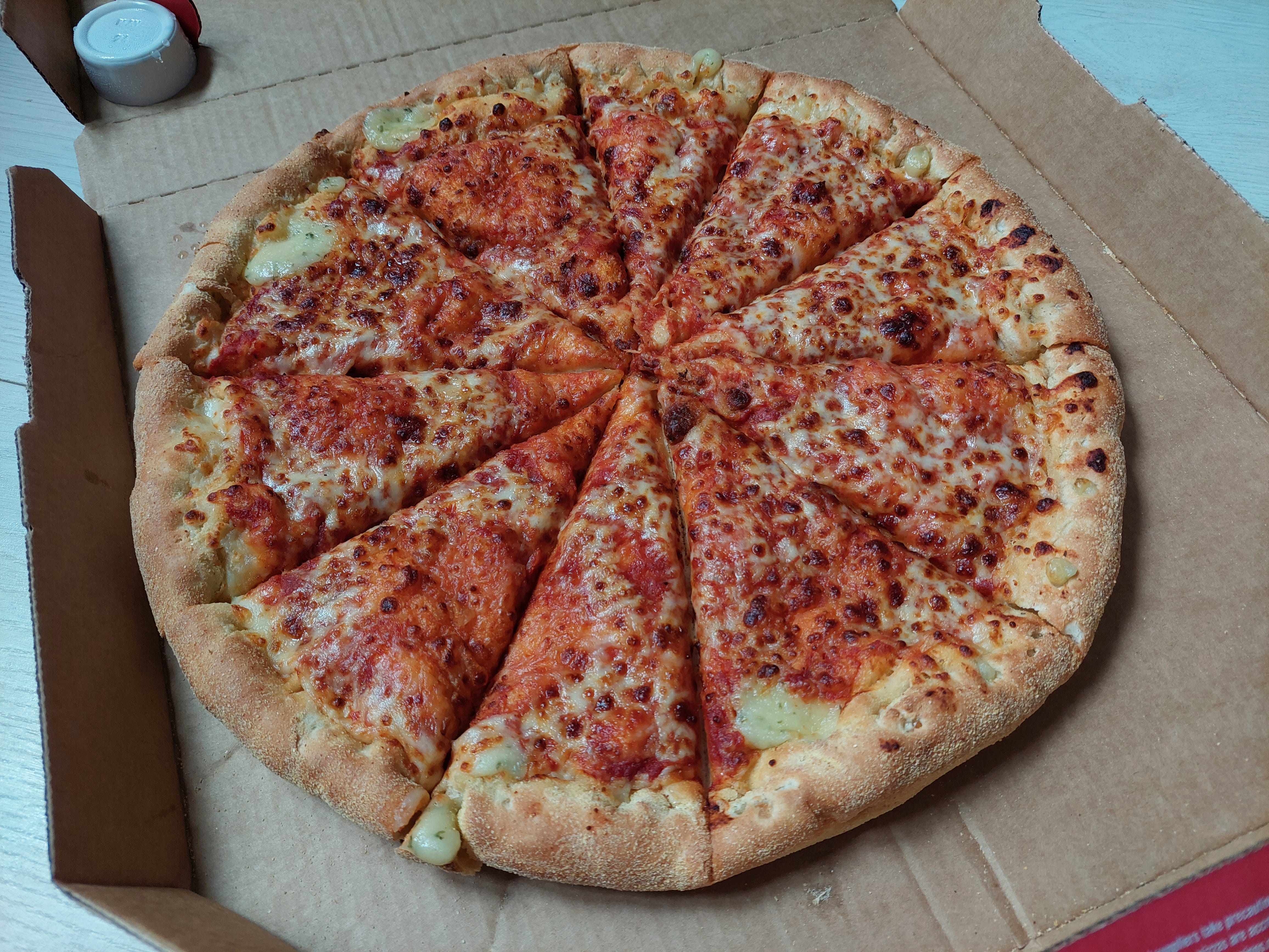 Pizza mit Käse und Tomaten von Domino's, präsentiert in einer Schachtel