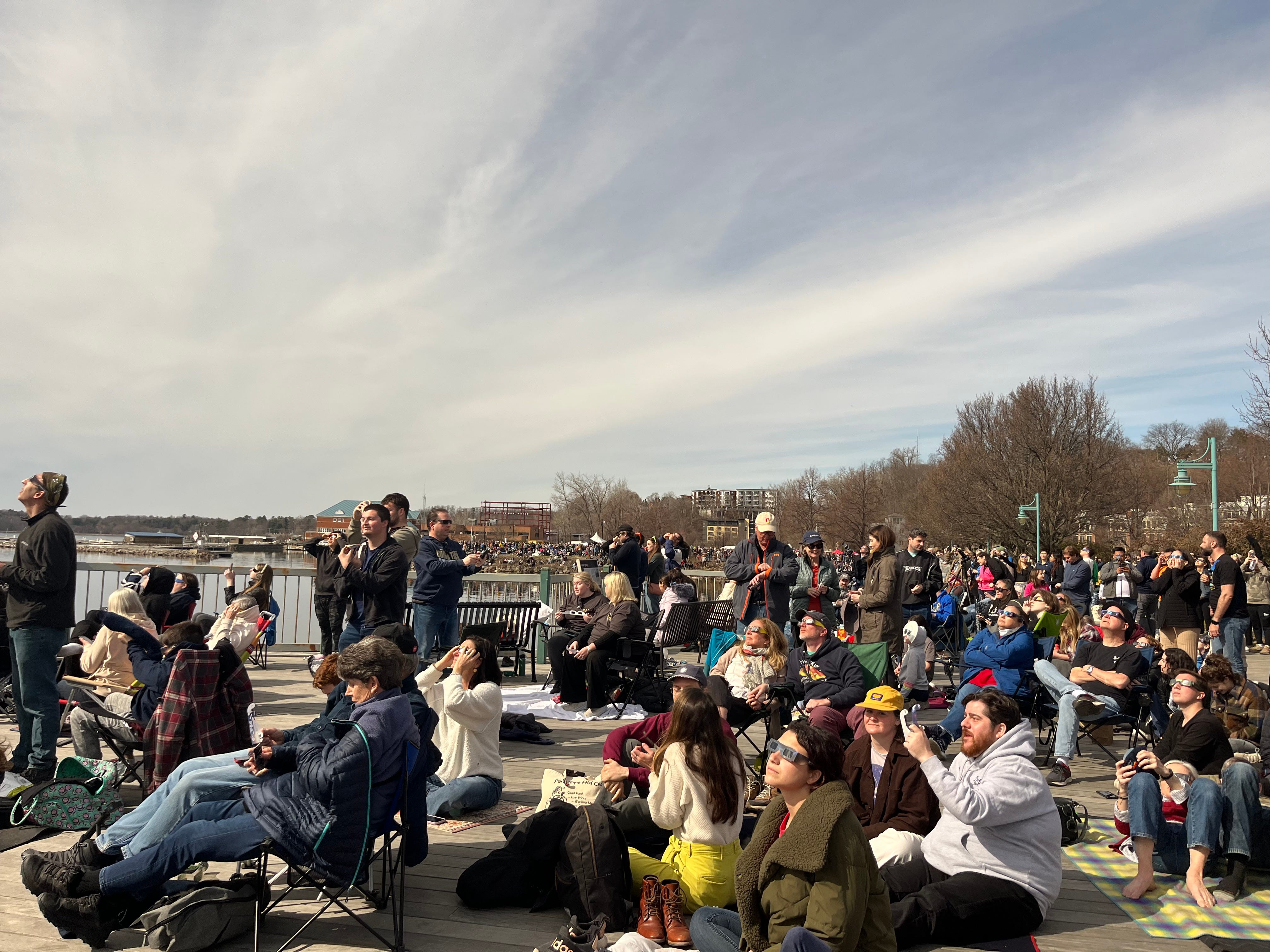 Eine riesige Menschenmenge von Sonnenfinsternis-Beobachtern sitzt auf der Promenade vor dem Lake Champlain in Burlington, Vermont.