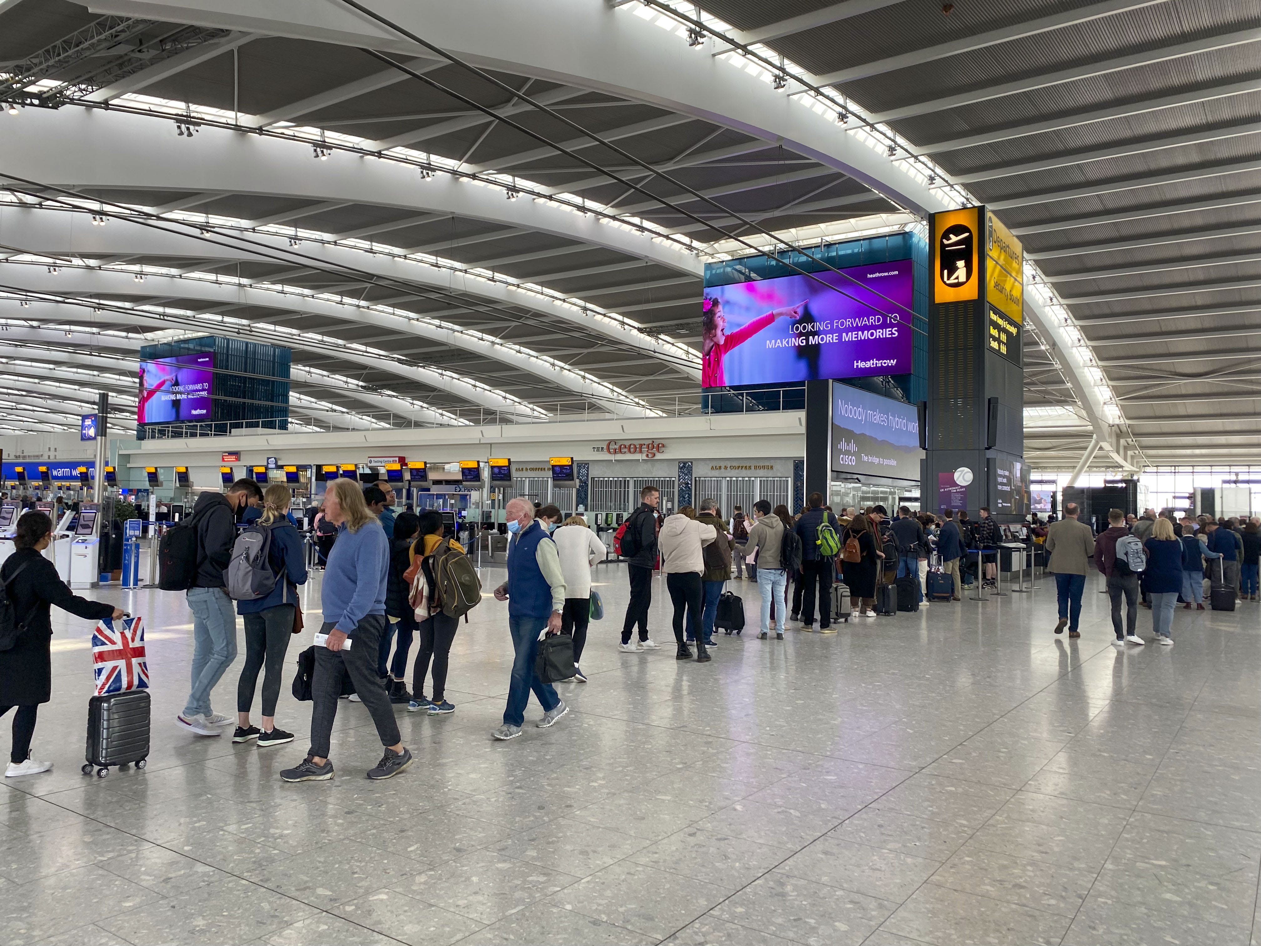 Passagiere stehen im Abflugterminal 5 des Flughafens Heathrow Schlange, um die Sicherheitskontrolle zu passieren.