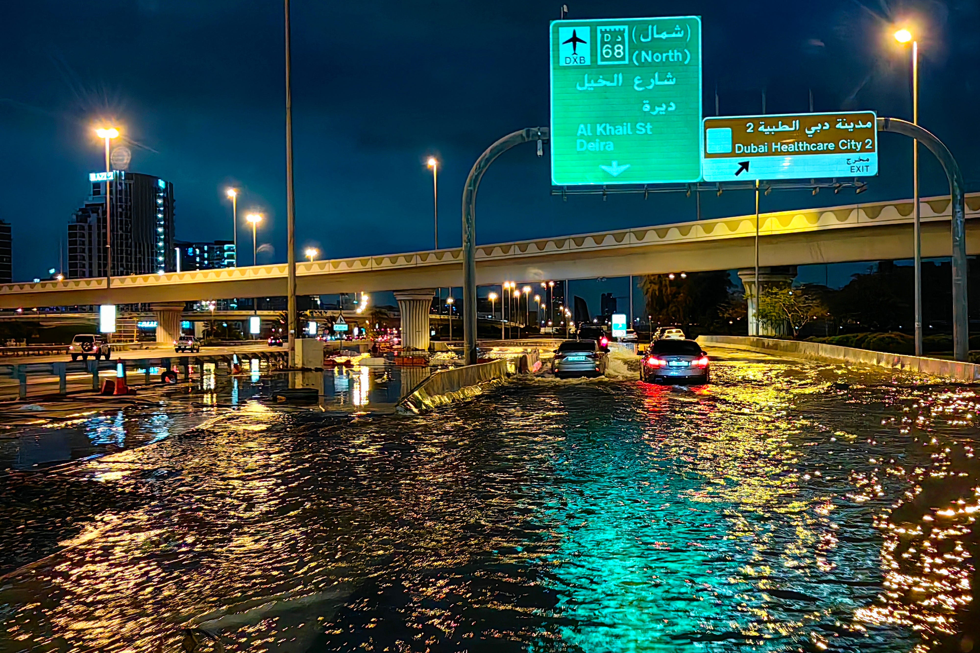 Autofahrer fahren nach heftigen Regenfällen in Dubai am frühen 17. April 2024 eine überflutete Straße entlang.