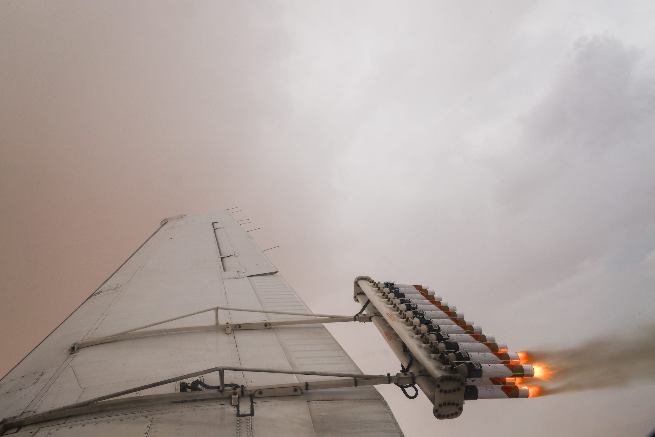 Flugzeugflügel mit einer Reihe von Rohren an der Rückseite, die Gas in einer dichten Wolke ausströmen lassen
