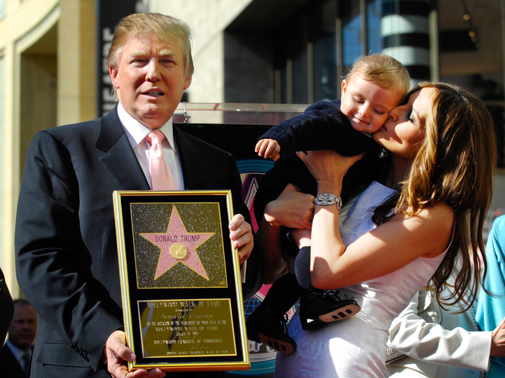 Donald Trump hält eine Nachbildung seines Sterns auf dem Hollywood Walk of Fame, während seine Frau Melania am 16. Januar 2007 in Los Angeles ihren Sohn Barron hält