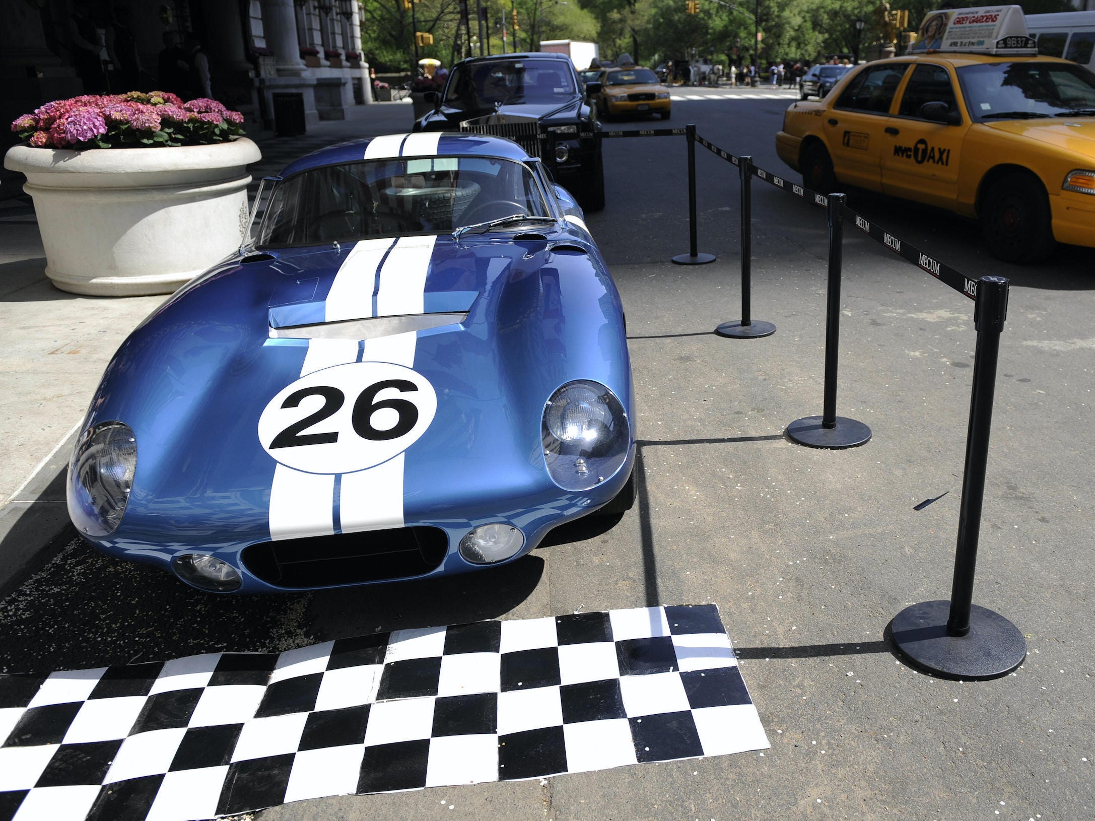 Shelby Daytona Cobra Coupé parkte auf der Straße in New York City, während ein gelbes Taxi vorbeifuhr