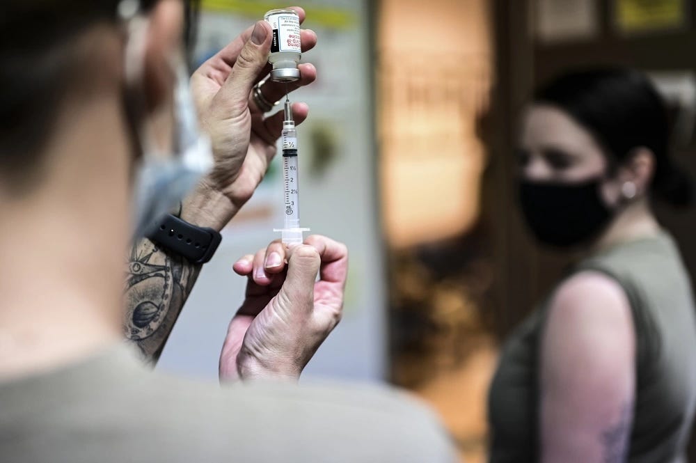 Ein Flugmedizintechniker füllt eine Spritze mit dem COVID-19-Impfstoff