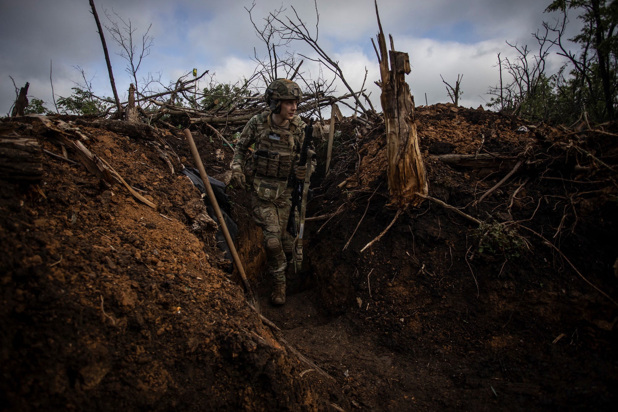 Ein ukrainischer Soldat geht in einem Schützengraben an einer Stelle spazieren