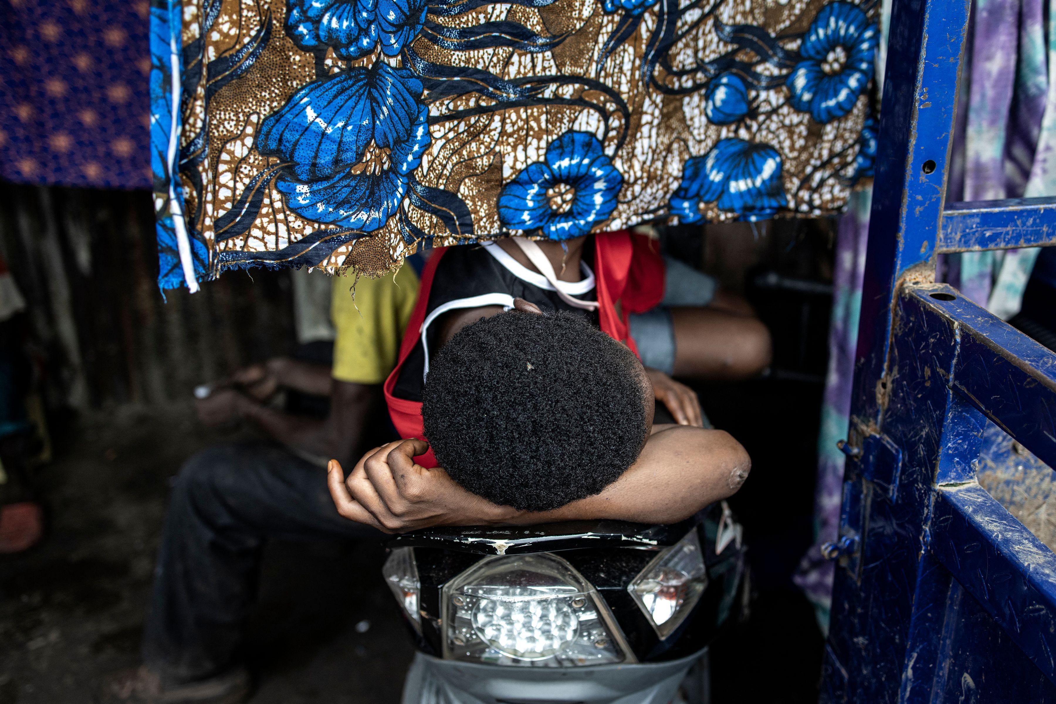 Ein Mann schläft am 21. Juni 2023 auf einem Motorrad in einer Drogenhöhle auf der Mülldeponie Kington in Freetown.