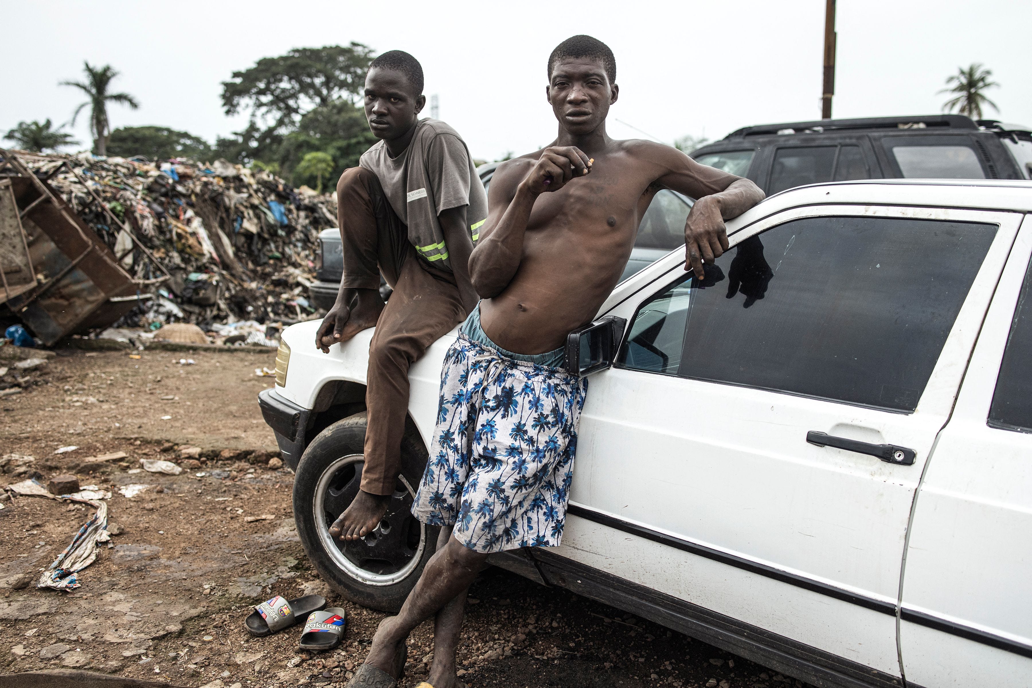 Zwei Männer entspannen sich am 21. Juni 2023 in einem Auto auf der Mülldeponie Kington in Freetown. In den letzten Jahren wird Kush, eine Mischung aus verschiedenen Chemikalien und Pflanzen, die die natürlichen Eigenschaften von Cannabis nachahmen, nach Angaben der National Drug Agency immer häufiger verwendet Wird von Jugendlichen in Sierra Leone verwendet.