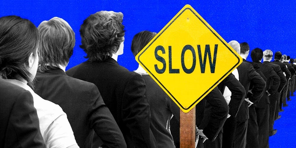 Menschen stehen in der Schlange vor einem Straßenschild mit der Aufschrift „langsam“