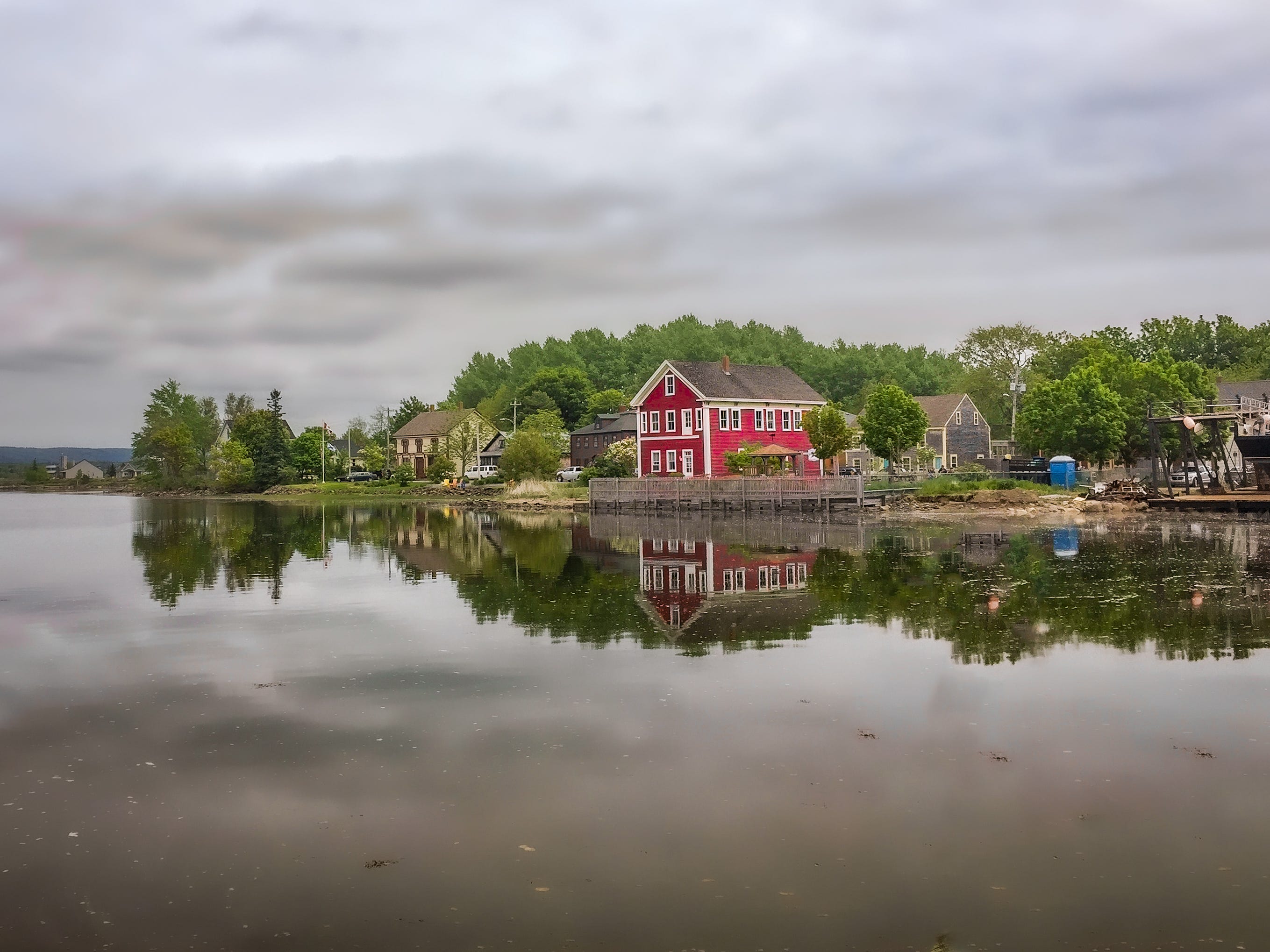 Häuser spiegeln sich in einem See mit grauem Himmel in Maryland.
