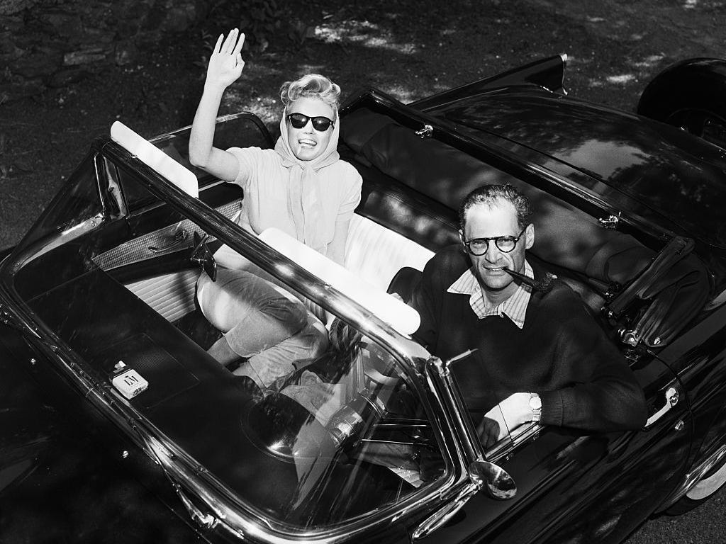 Marilyn Monroe winkt aus Arthur Millers Cabrio, als die Frischvermählten am Tag nach ihrer Hochzeit ihr Haus in Roxbury, Connecticut, für ein Picknick verlassen.