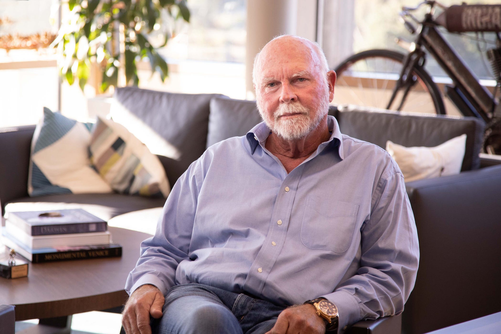 Craig Venter sitzt im Büro, leichtes Lächeln
