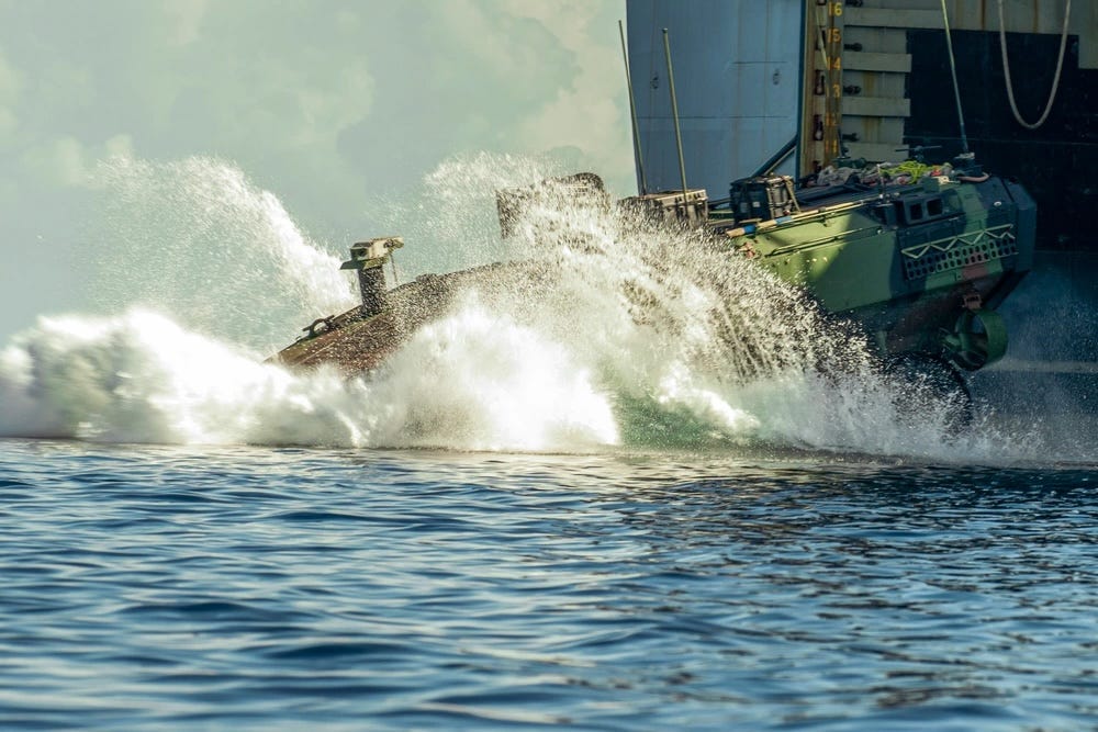 Ein amphibisches Kampffahrzeug des US Marine Corps spritzt vom amphibischen Docklandungsschiff USS Harpers Ferry