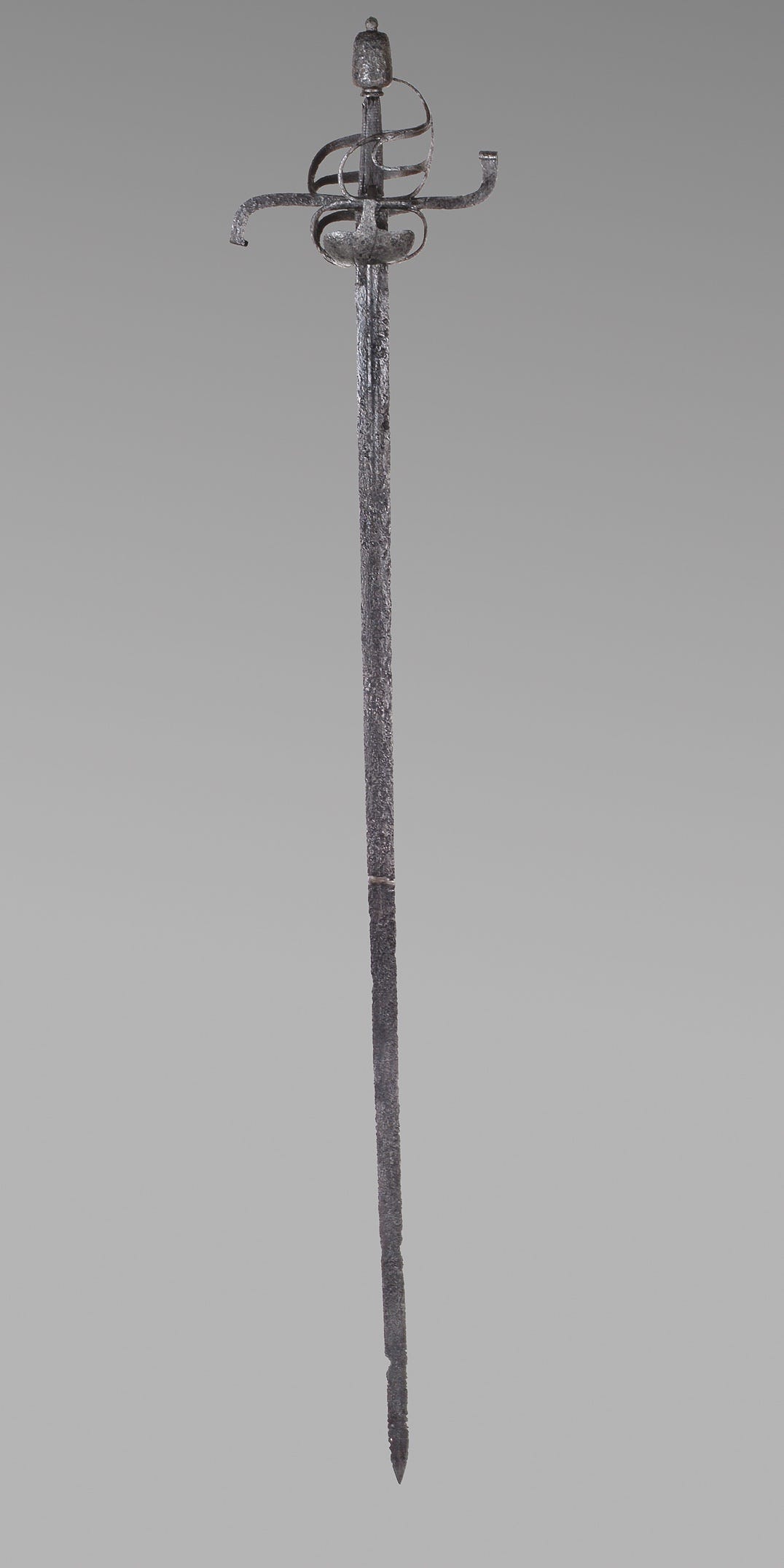 Langes, dünnes Metallschwert mit dünnem, fließendem Schutz, der sich spiralförmig um den Griff windet