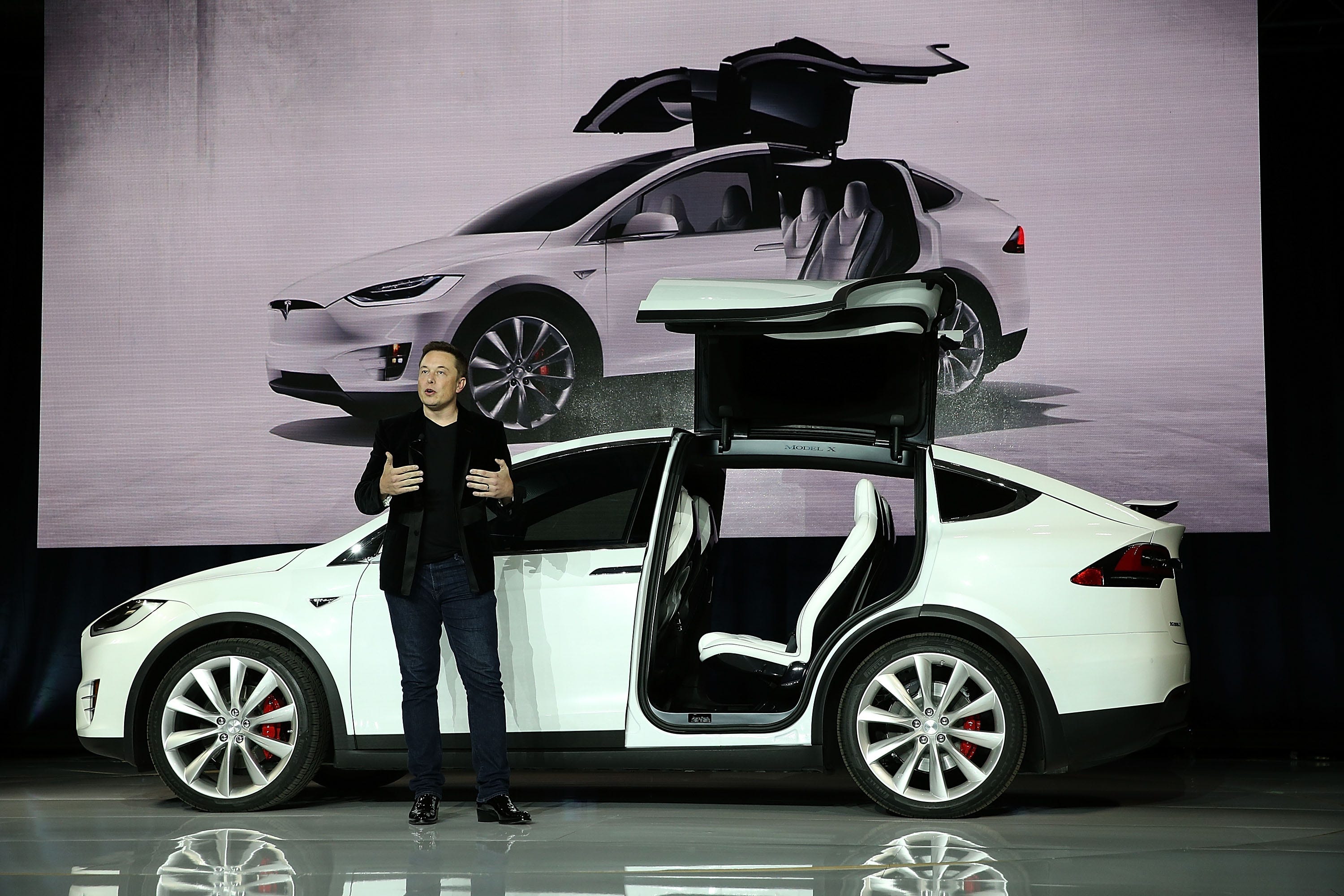 Elon Musk steht während einer Launch-Veranstaltung vor einem Tesla Model X Crossover-SUV.