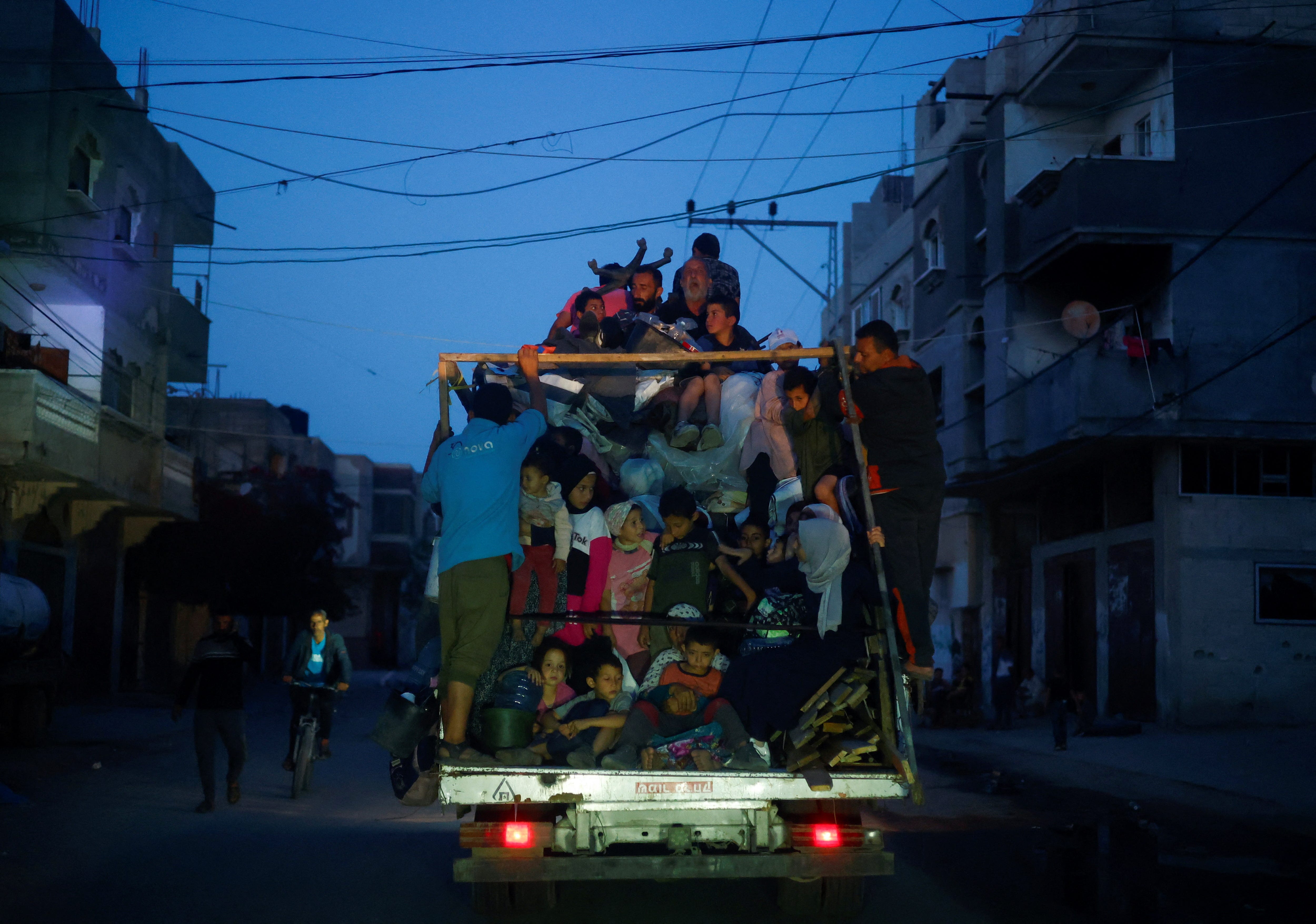 Palästinenser fahren in einem Fahrzeug mit, als sie am 9. Mai 2024 aus Rafah fliehen.