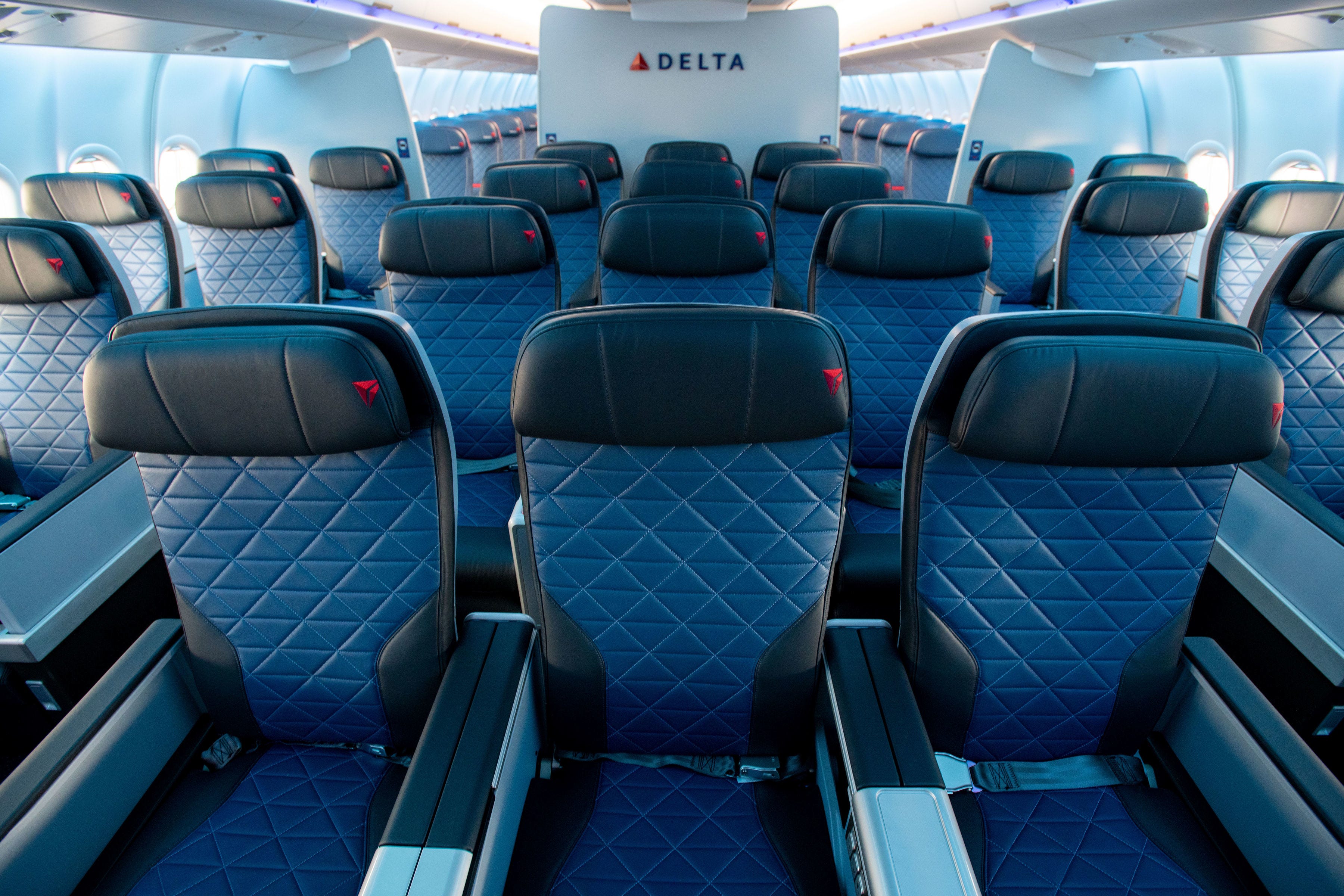 Blick über die Reihen der internationalen Premium-Economy-Sitze von Delta Premium Select auf ein Delta-Logo an Bord eines Airbus A330-900neo.