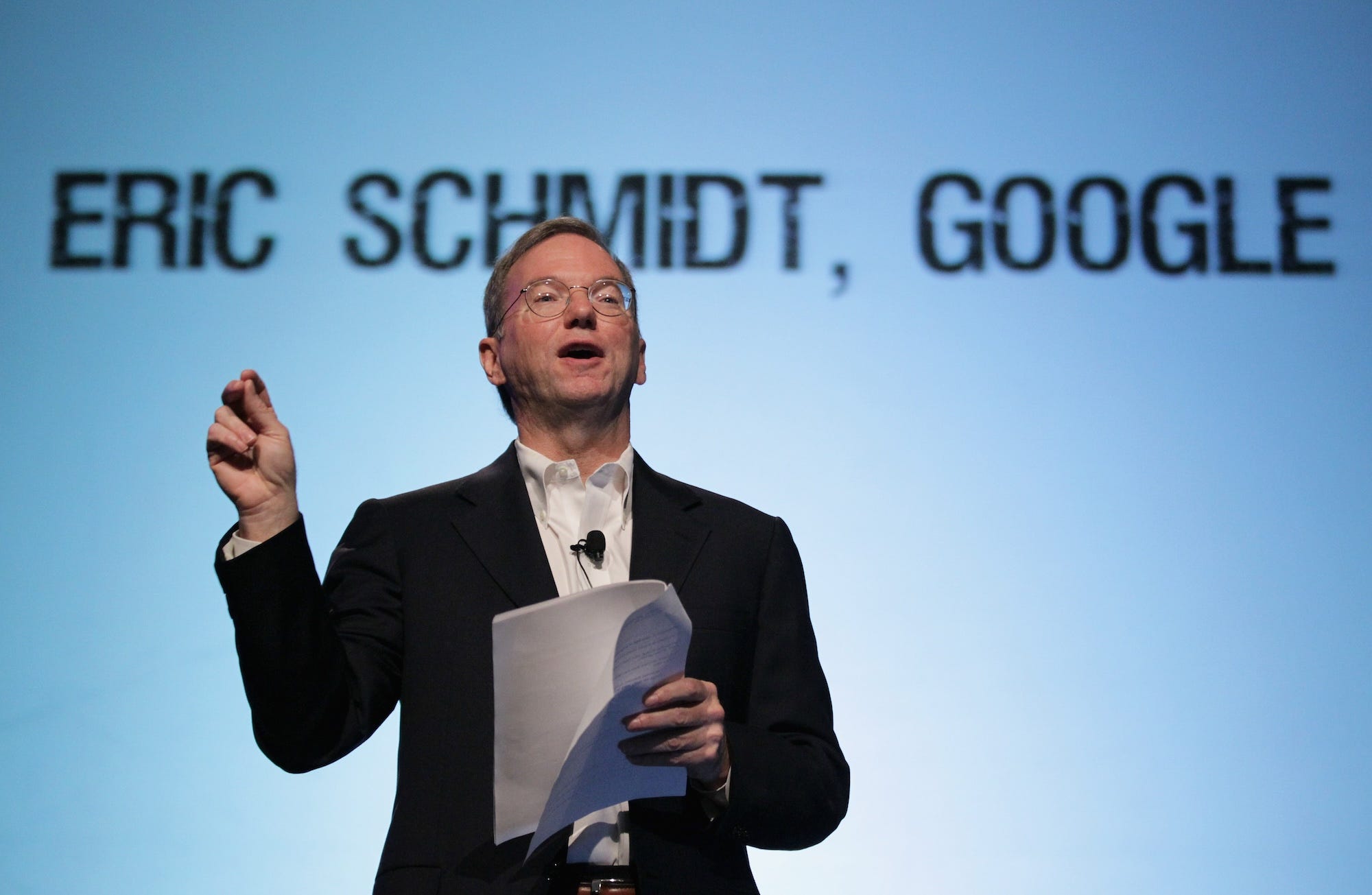 Der ehemalige Google-Chef Eric Schmidt spricht vor einer Kulisse mit seinem Namen.