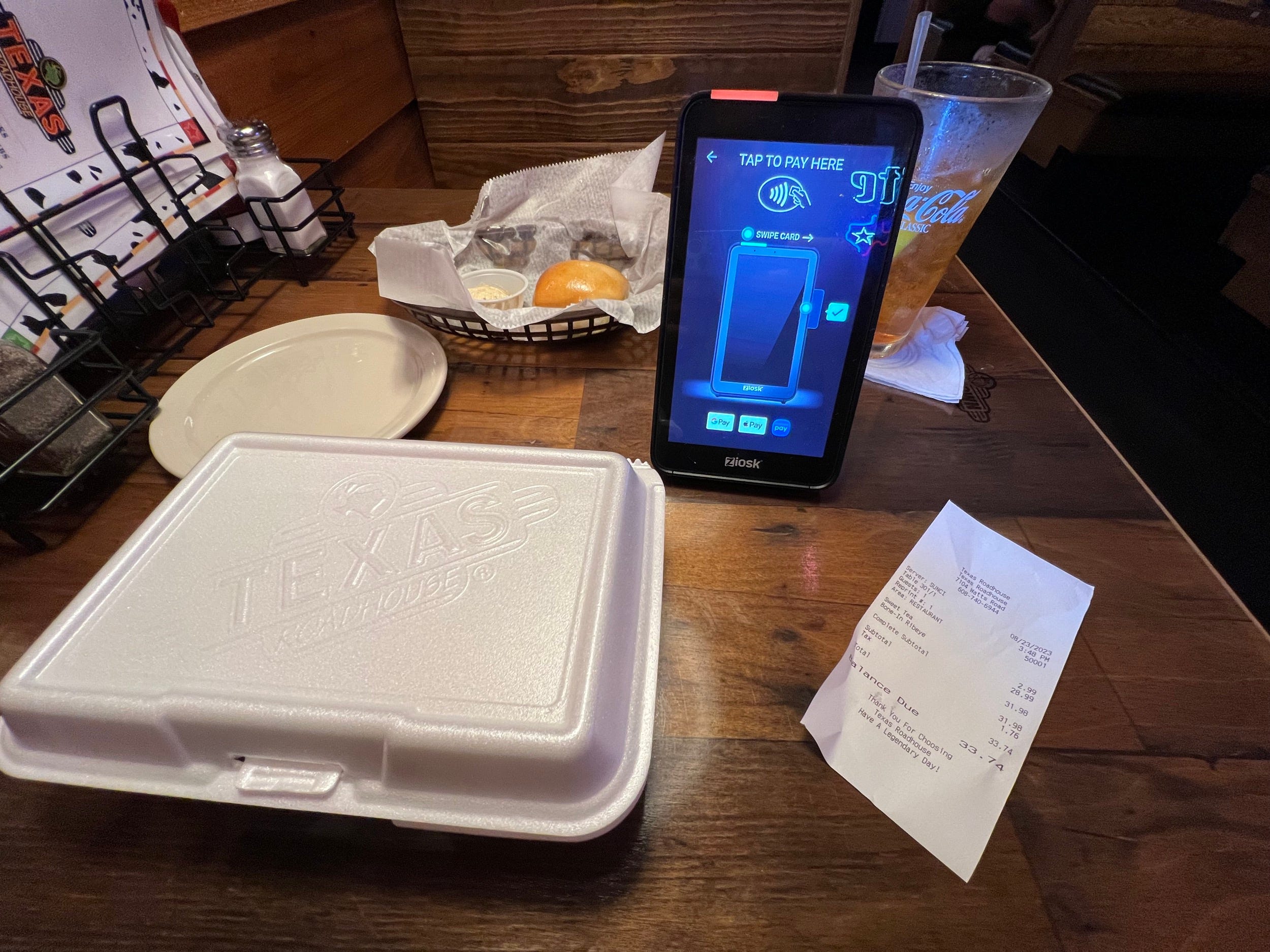 Eine To-Go-Box und ein elektronisches Zahlungsgerät in einem Texas Roadhouse