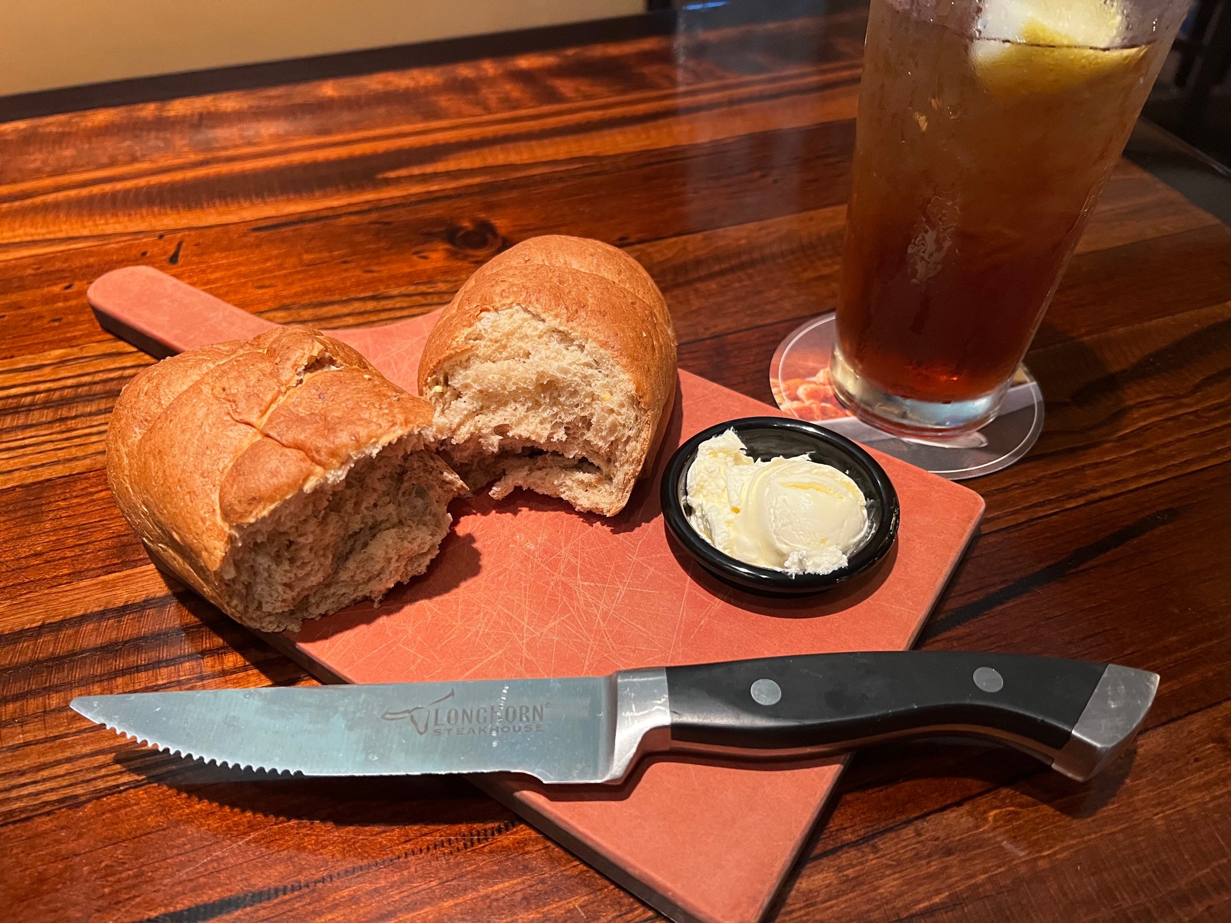 Frisches Brot, süßer Tee und ein Longhorn Steakhouse-Steakmesser
