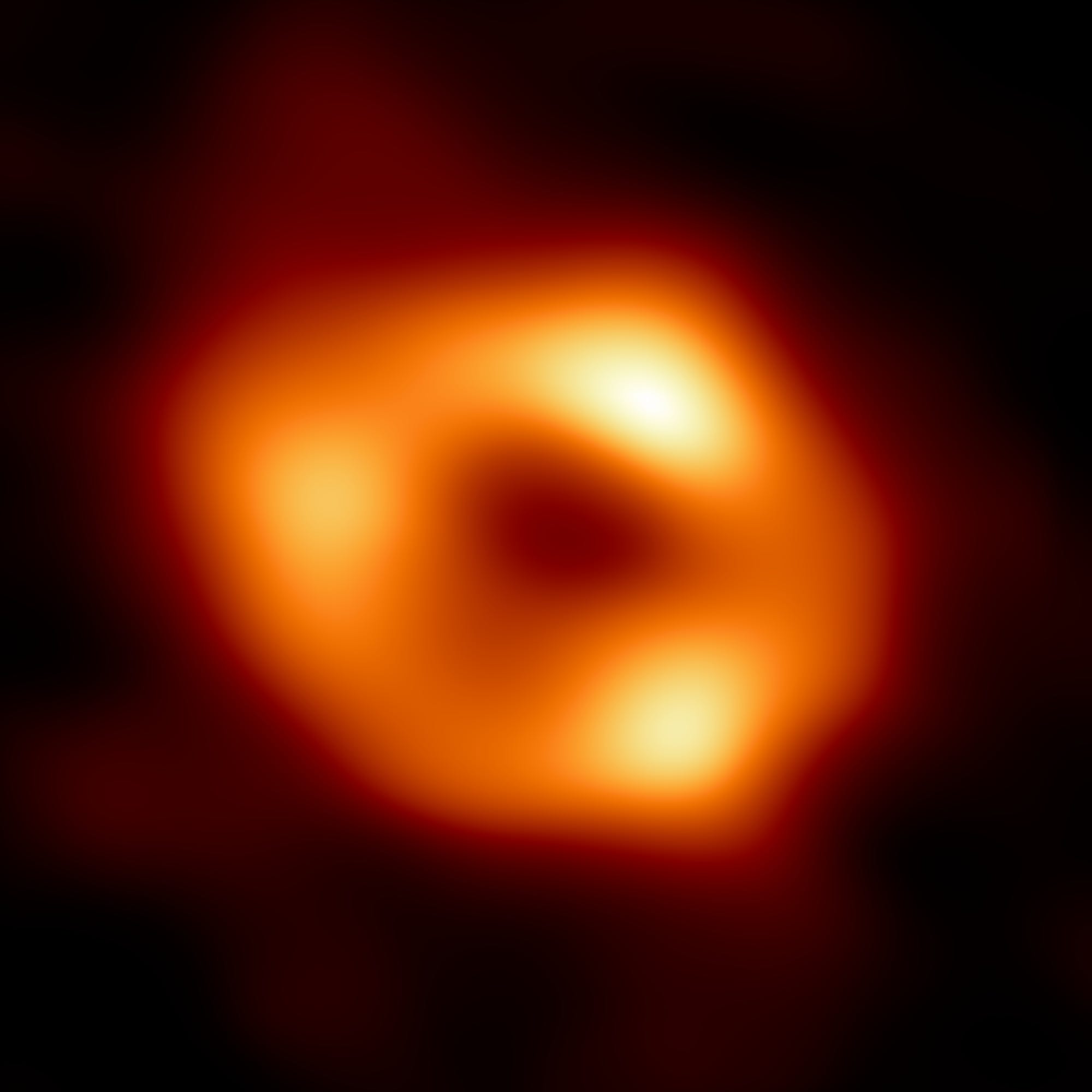 verschwommener roter Kreis um ein schwarzes Zentrum, der das erste Foto des supermassereichen Schwarzen Lochs im Zentrum unserer Galaxie darstellt