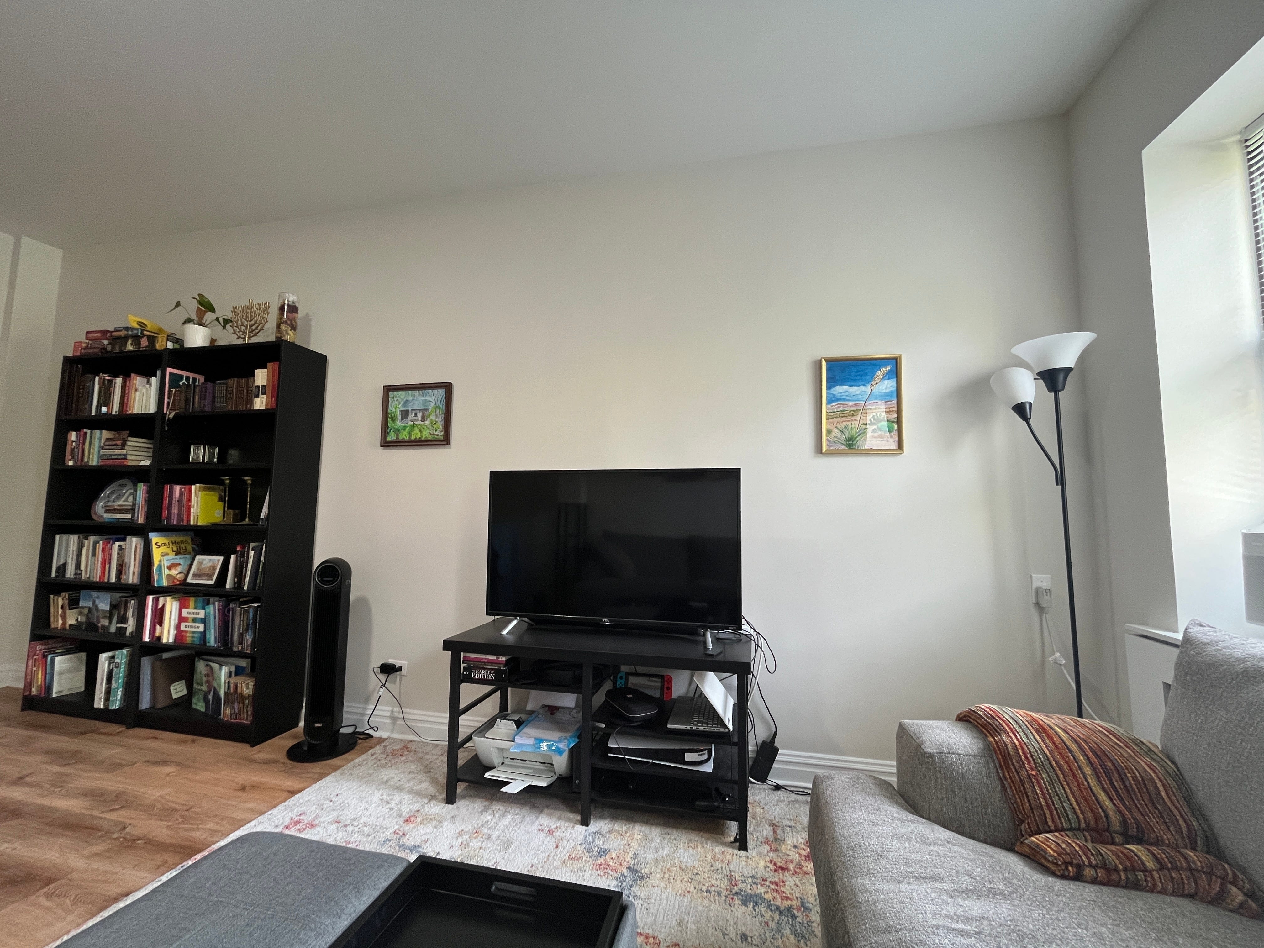 Ein New Yorker Wohnzimmer mit Gemälden an der Wand und Bücherregalen