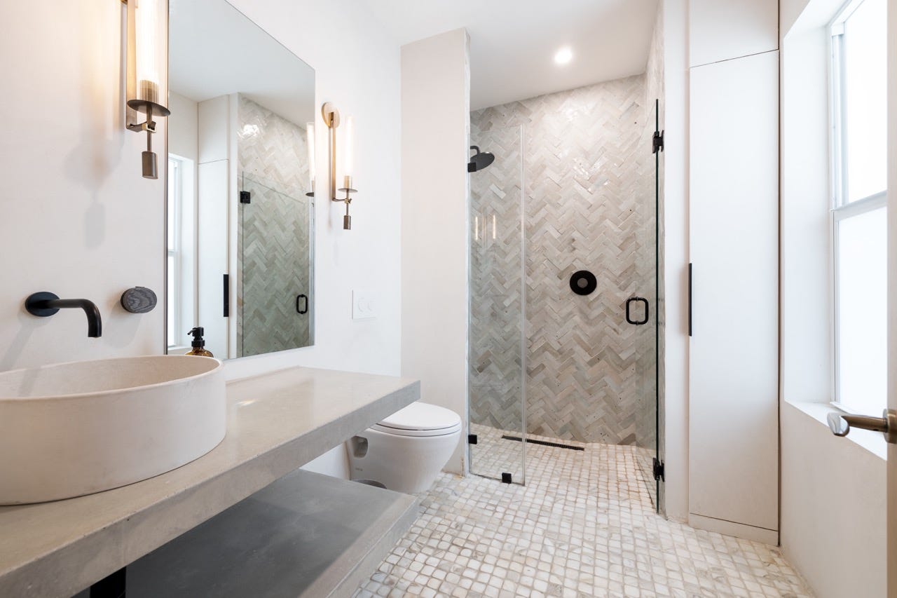 Weiß-graues Badezimmer mit Dusche ohne Stufe und großem Spiegel
