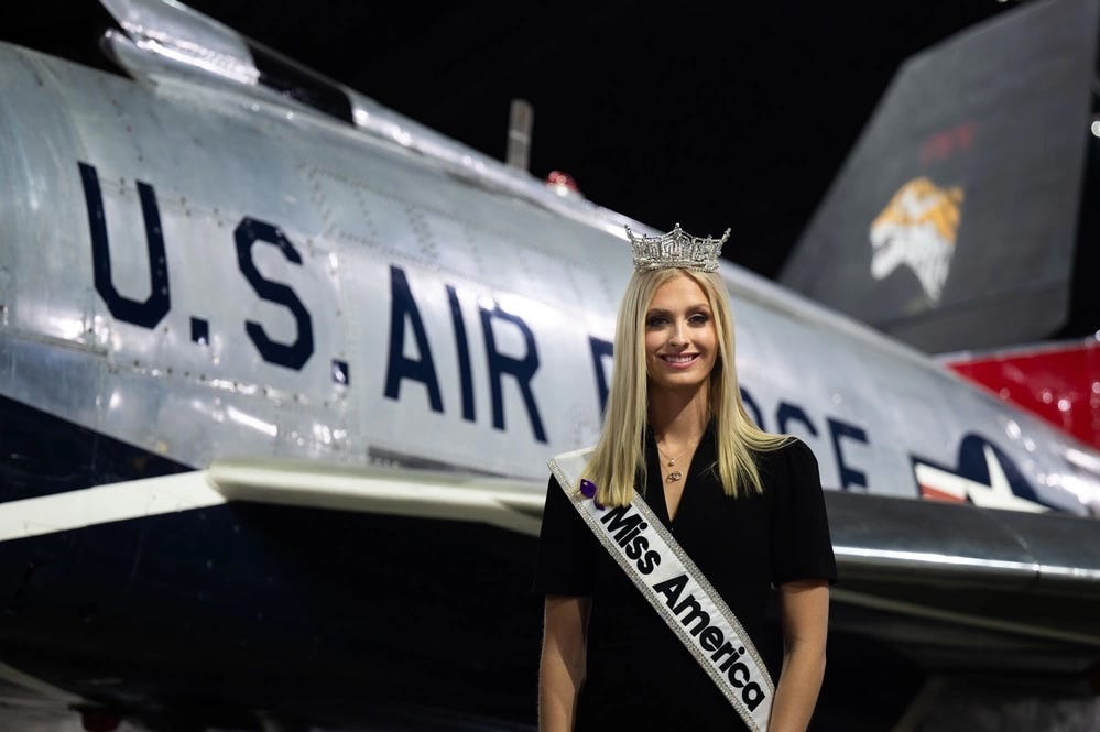 Madison Marsh posiert mit ihrer Miss America-Schärpe und -Krone vor einem Flugzeug im Nationalmuseum der US Air Force.