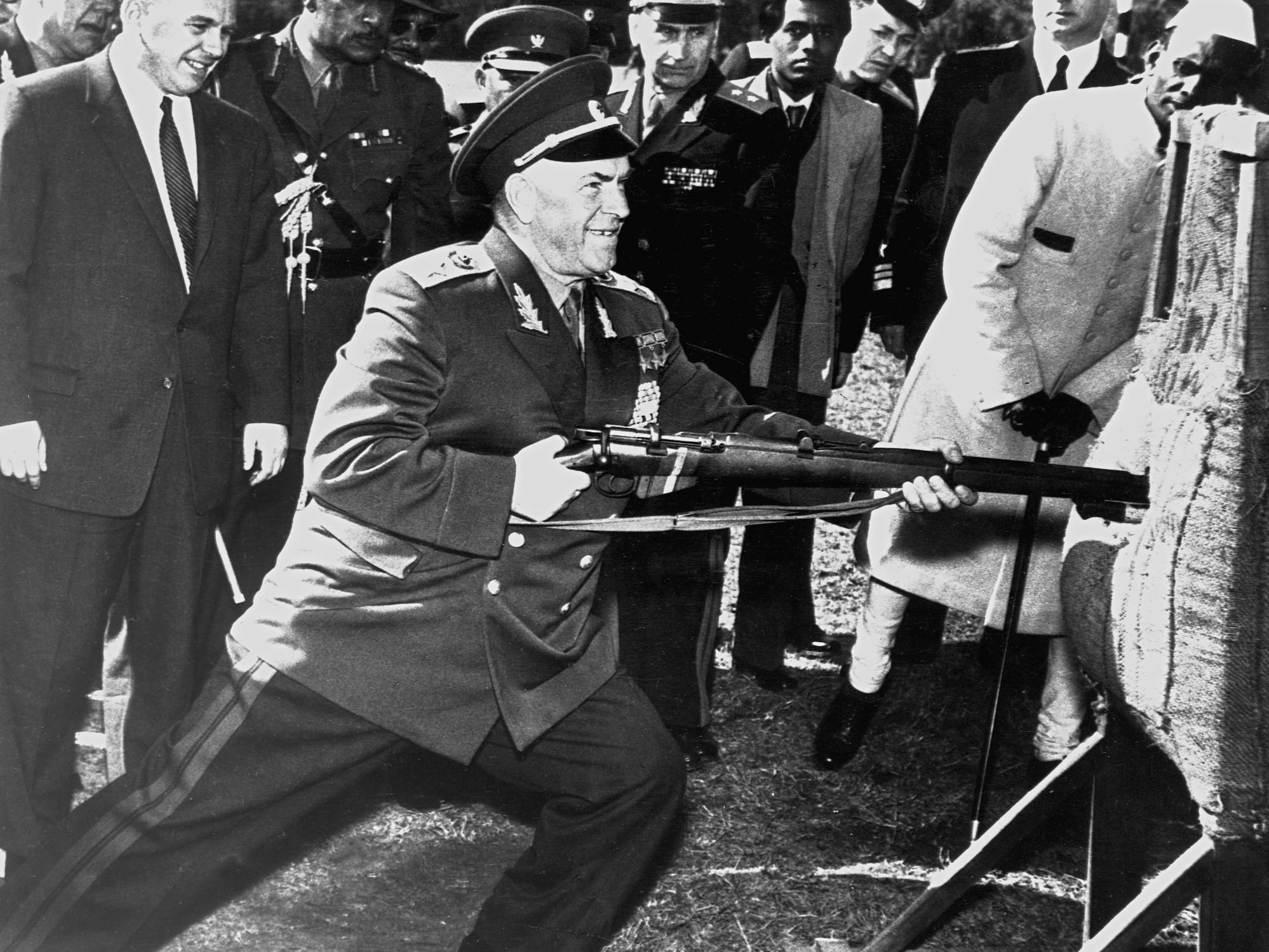 Der sowjetische Verteidigungsminister Georgi Schukow stößt das Bajonett eines Gewehrs in eine Attrappe, während eine Gruppe zuschaut
