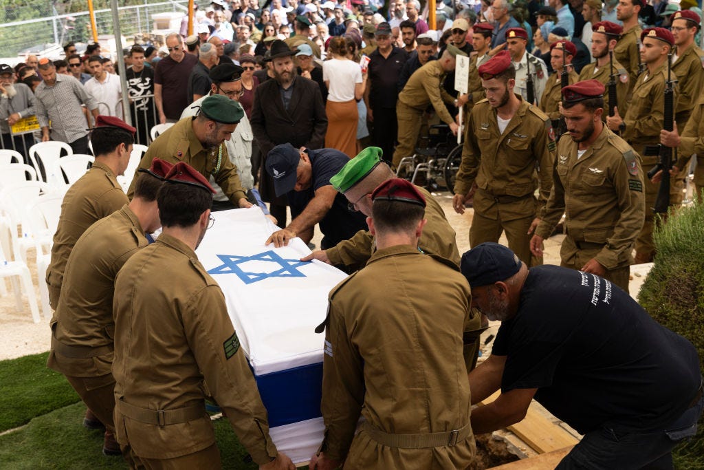 KARNEI SHOMRON, WESTJORDANLAND – 16. MAI: Israelische Soldaten legen den Sarg im Grab bei einer Beerdigung für Sgt. der israelischen Verteidigungskräfte ab.  Gilad Aryeh Boim am 16. Mai 2024 in Karnei Shomron, Westjordanland.  Der Sergeant war einer von fünf Soldaten, die gestern bei einem „Friendly Fire“-Vorfall in Gaza getötet wurden, als ein israelischer Panzer auf ein Gebäude schoss, in dem sich die Männer befanden. Sieben weitere wurden verletzt. (Foto von Amir Levy/Getty Images.) )