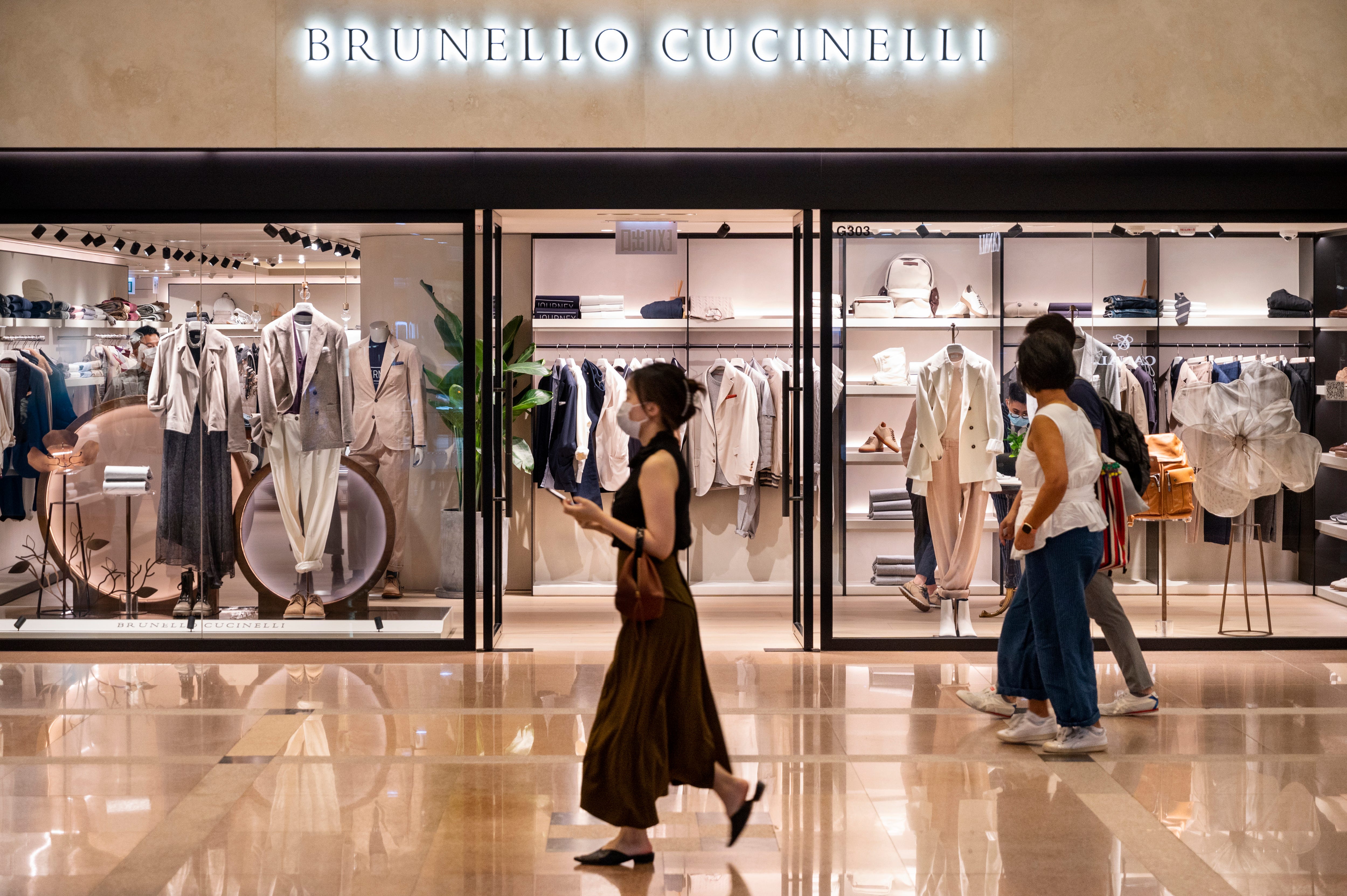 Käufer laufen am Geschäft der italienischen Luxusmodemarke Brunello Cucinelli in Hongkong vorbei.