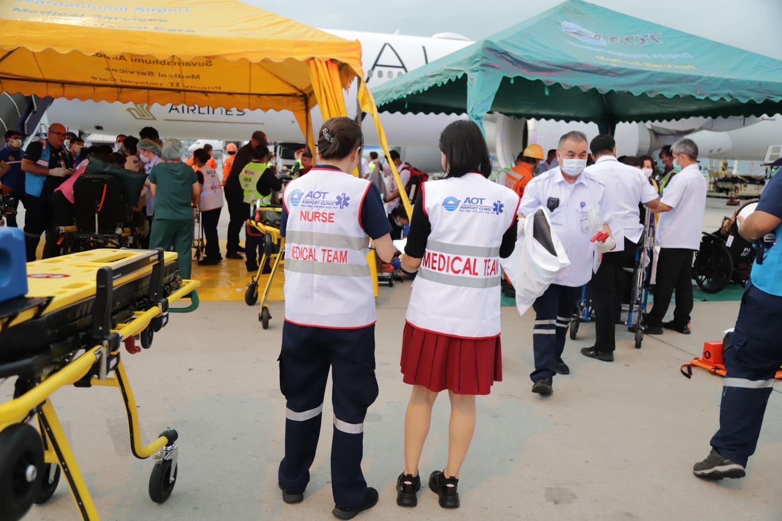 Zwei Mediziner stehen vor Zelten, die zur Behandlung der Verletzten des Singapore Airlines-Fluges 321 aufgestellt wurden.