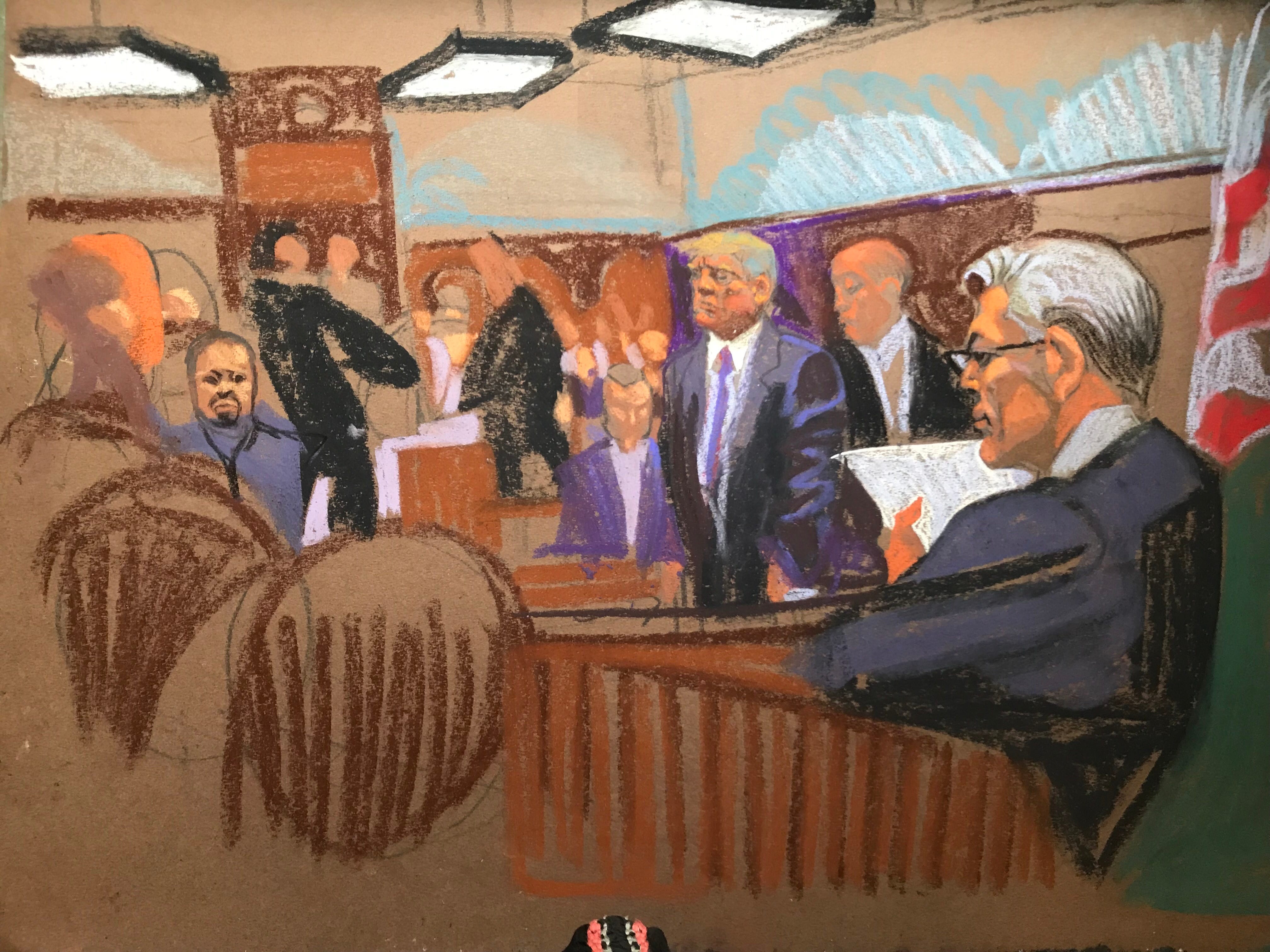 Eine Gerichtsskizze von Donald Trump, der zwischen anderen Menschen im Gerichtssaal steht.