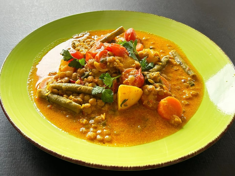 Vegetable curry with lentils on a green plate