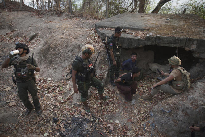 Members of the Karen National Liberation Army and the People's Defense Force examine two captured soldiers after the capture of an army outpost, in Myawaddy, Burma, April 11, 2024.