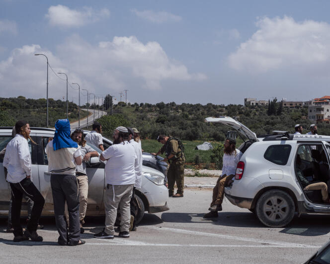 Israeli settlers supervised by soldiers block the entrance to the Palestinian village of Turmus Aya, also leading to the village of Al-Moughaïr, in the occupied West Bank, Saturday April 13, 2024. 