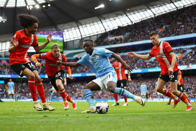 Manchester City's Belgian winger Jeremy Doku surrounded by four Luton Town defenders during his team's 5-1 victory on Saturday at the Etihad Stadium in Manchester.