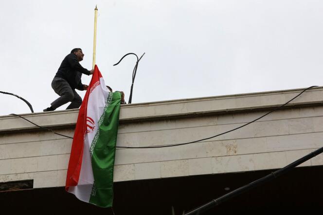 A staff member installs the Iranian flag atop the new consular annex of the Iranian Embassy in Damascus on its inauguration day, April 8, 2024.