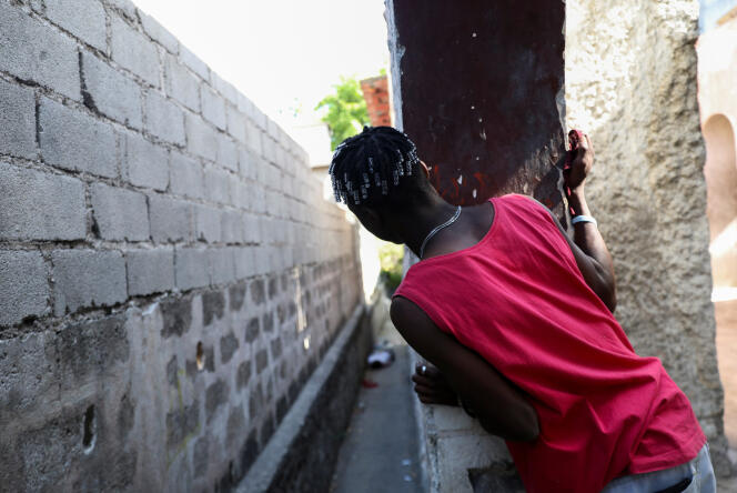 A man looks at a dead body, as rival gangs battle for control of territory and the state remains largely absent, in Port-au-Prince, Haiti, April 1, 2024. 