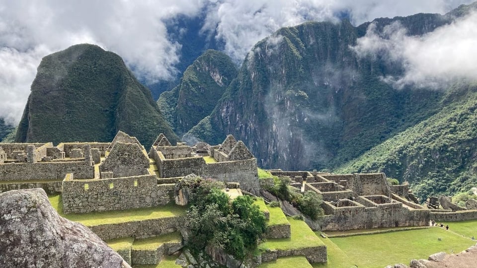 Tourists next to Inca buildings.