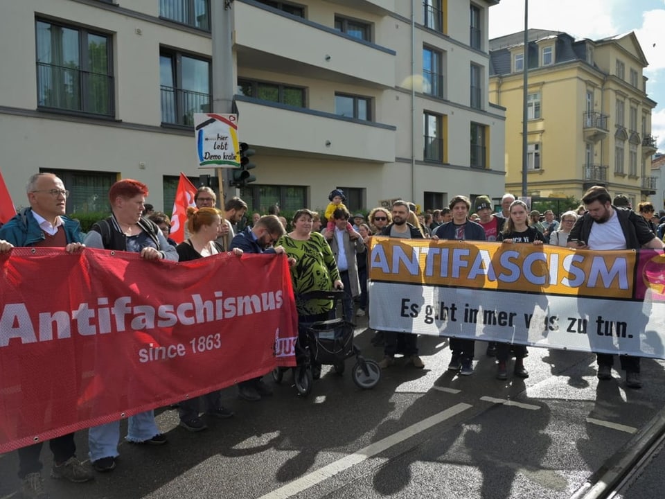 Group of people at a demonstration with a large banner that says 'Antifascism since 1863'.