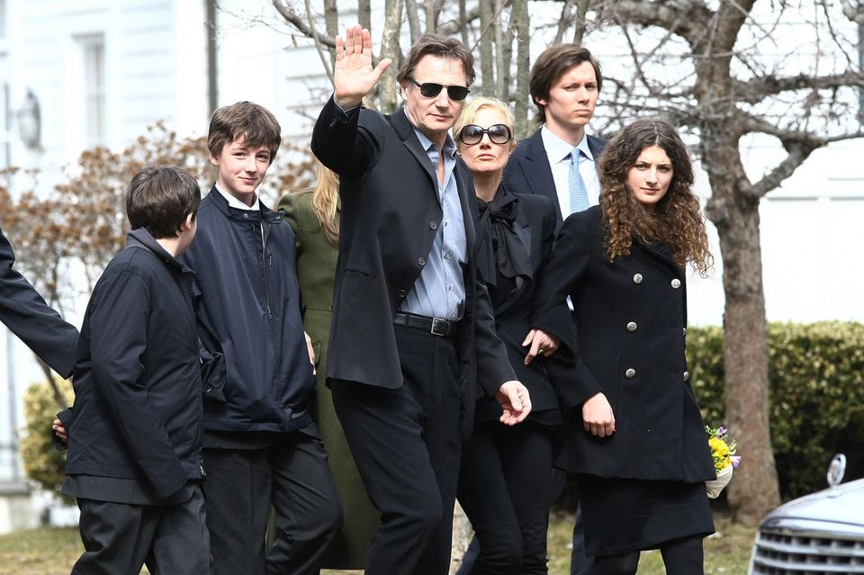 Liam Neeson (waving) with his sons Daniel (left) and Micheál Neeson (right) at Natscha Richardson's funeral at St. Peter's Lithgow Episcopal Church on March 22, 2009 in Lithgow, New York.