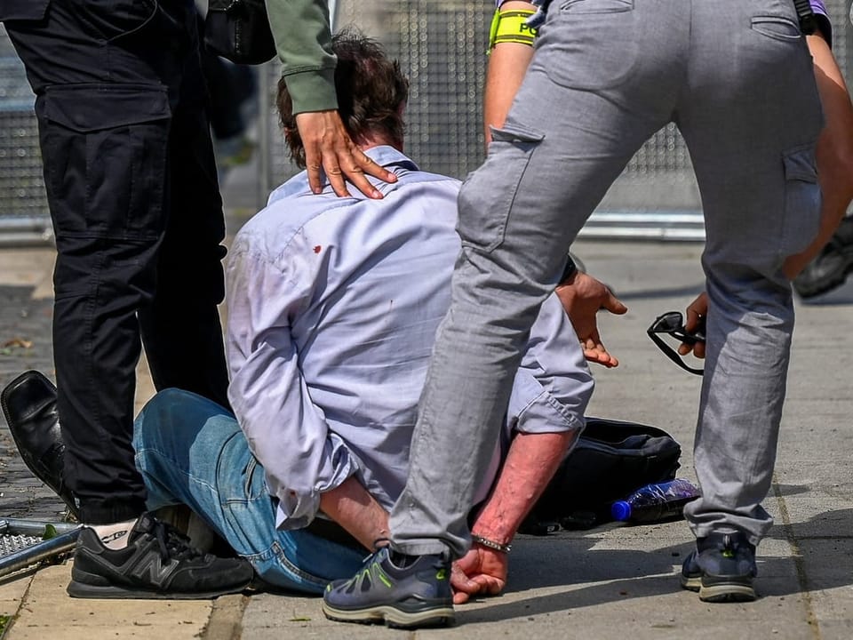 Police arrest a person on the ground.