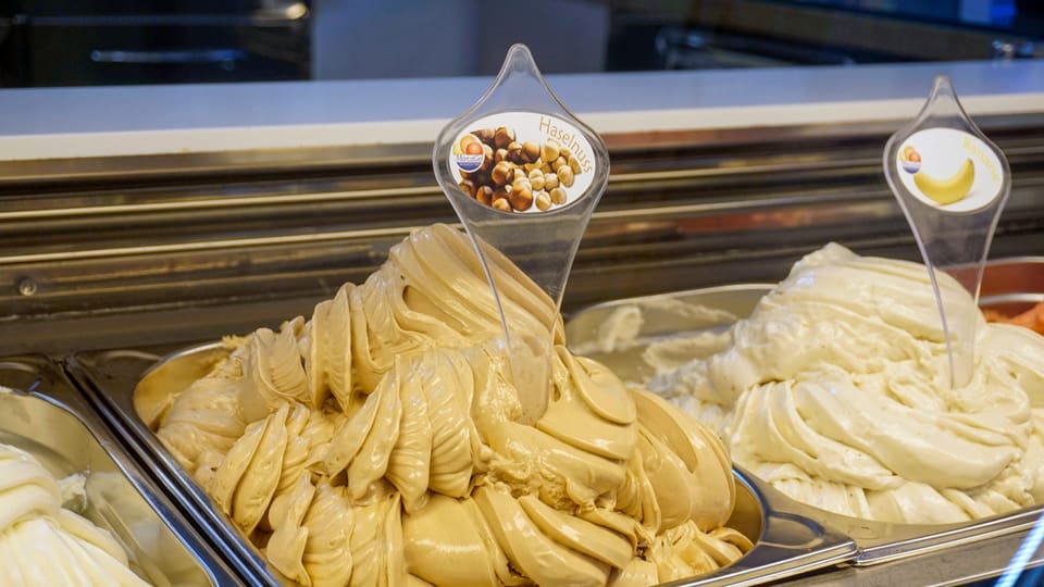 Different types of ice cream in an ice cream parlor with a focus on nut ice cream.