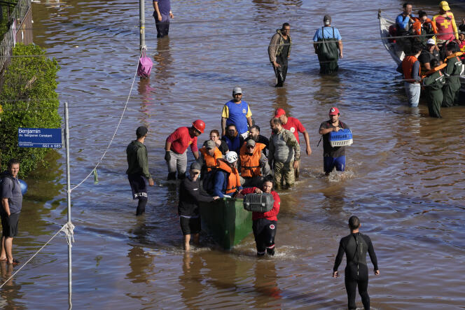 People evacuate an area flooded by heavy rains in Porto Alegre, Rio Grande do Sul state, Brazil, May 9, 2024.