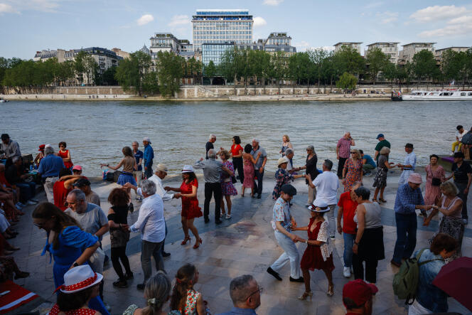 People dance on the banks of the Seine in Paris on May 11, 2024.
