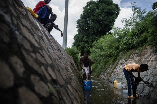People collect wastewater in the Cavani district, in Mamoudzou (Mayotte), February 11, 2024. 