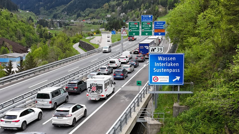 Traffic jam on a multi-lane highway in a mountainous landscape with signposts