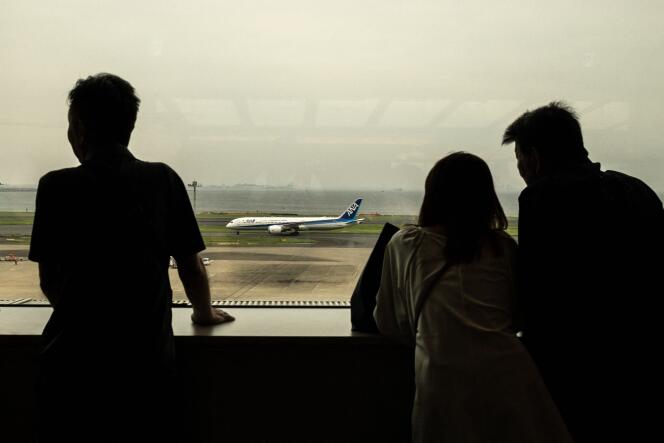 At Tokyo airport, passengers observe a plane that is not powered by hydrogen.