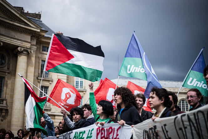 Demonstrators brandish flags of Palestine, the Student Union and Raised Fist, a youth political collective attached to the Permanent Revolution organization, in Paris, May 3, 2024.