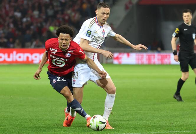 Lille defender Tiago Santos (red jersey) fighting with Lyon midfielder Nemanja Matic, at the Pierre-Mauroy stadium in Villeneuve-d'Ascq, May 6, 2024.